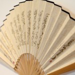 Writing on the Wall / Writing on Fans, live performance, writing with charcoal on an insignificant wall and on paper fans, 2012